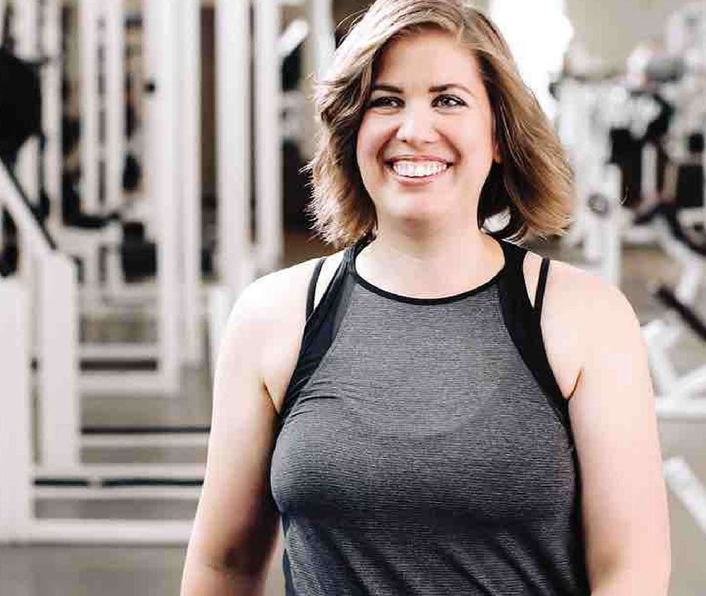 Woman smiling while walking through gym